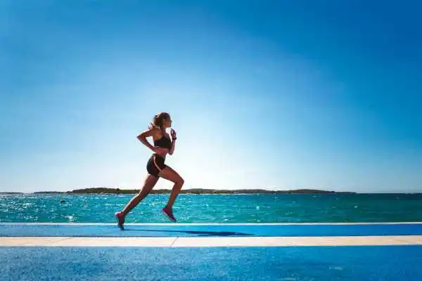 Woman running showing strong leg muscle Sutton
